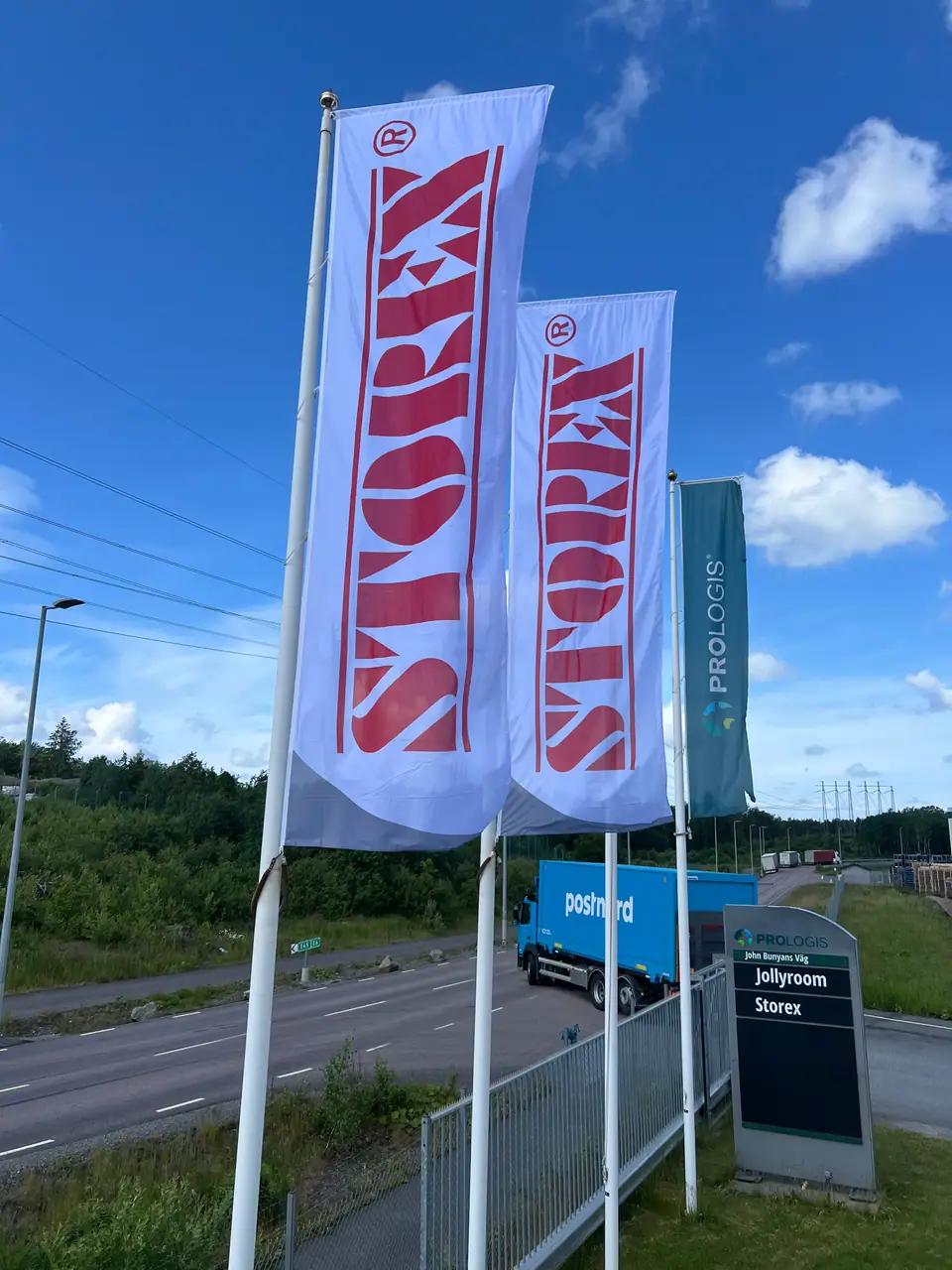 Tre höga företagsflaggor i marinpolyester för Storex monterade på flaggstänger