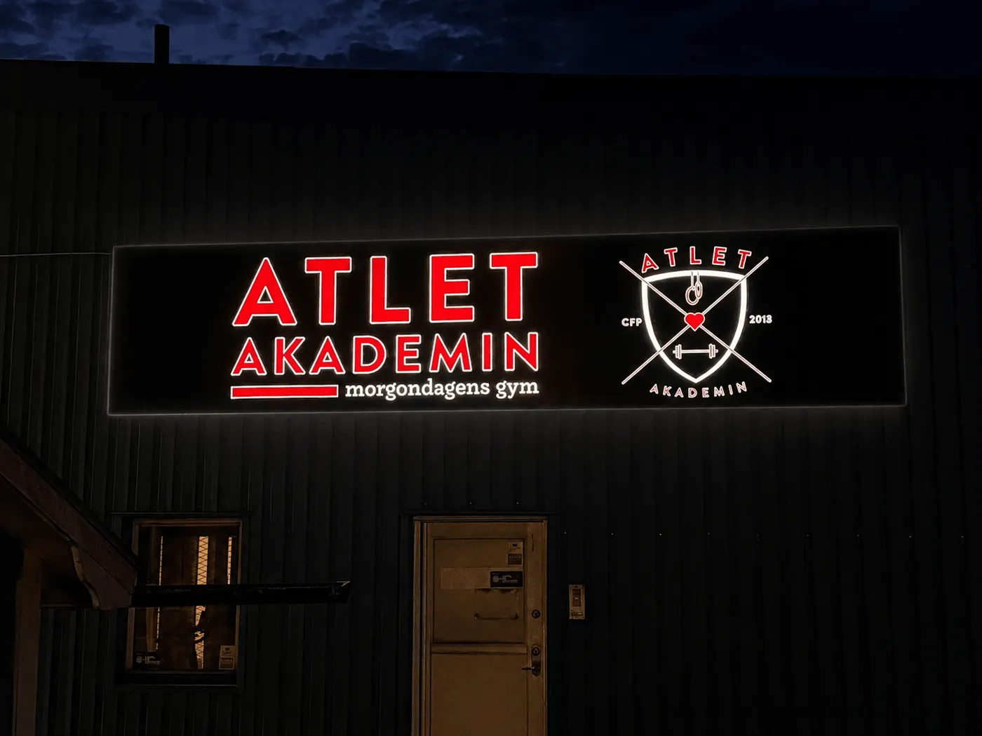 Ljusskylt med spännduksfront för Atlet Akademin på natten